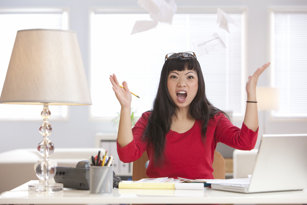 01 Oct 2010 --- Angry Asian woman throwing papers in home office --- Image by © Hill Street Studios/Blend Images/Corbis