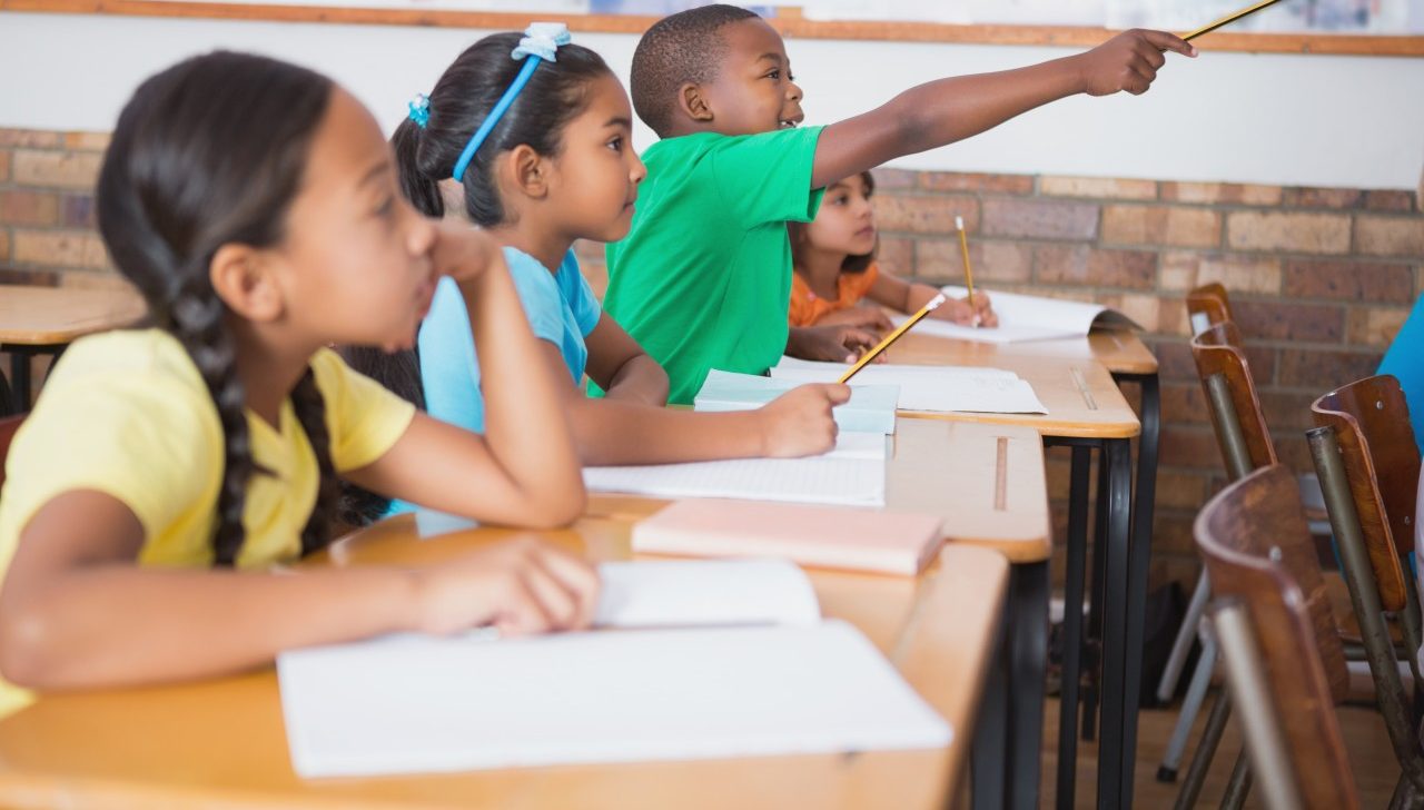 11 May 2014 --- Cute pupil raising hand in classroom --- Image by © Wavebreak Media LTD/Wavebreak Media Ltd./Corbis