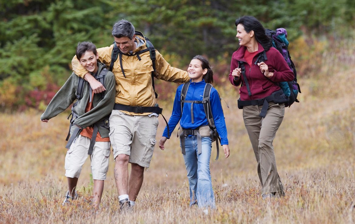 Family hiking through dry field --- Image by © Jeremy Woodhouse/Blend Images/Corbis