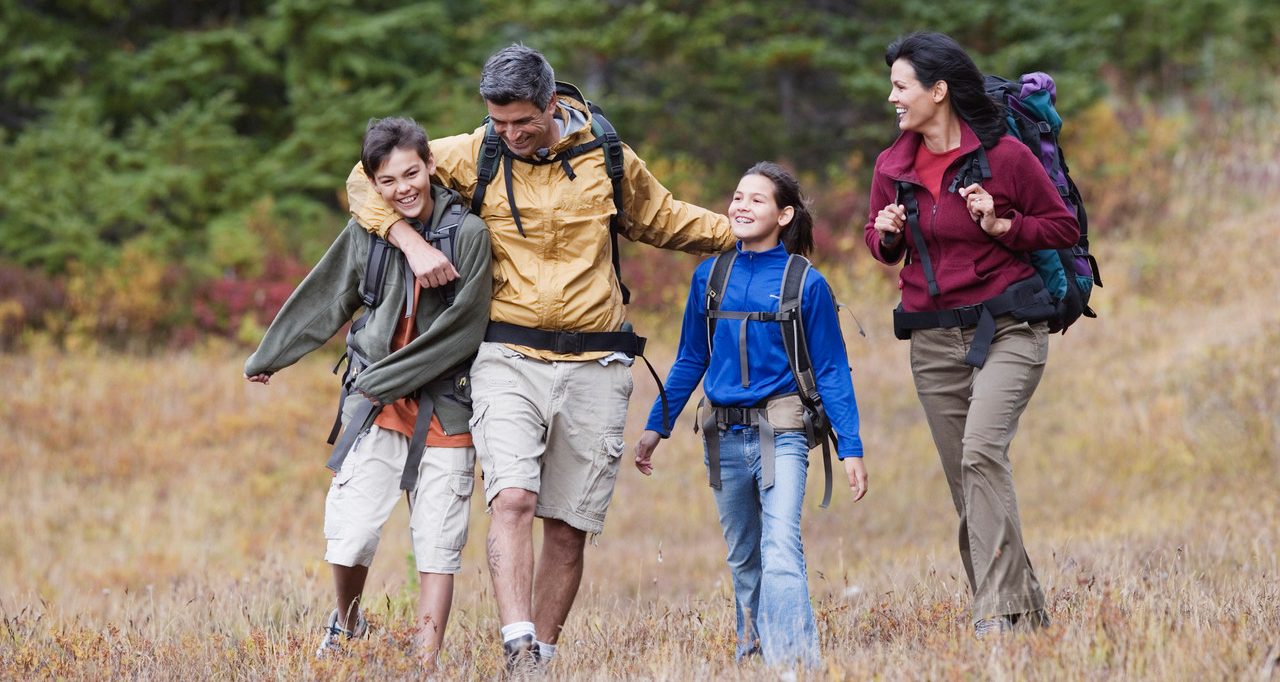 Family hiking through dry field --- Image by © Jeremy Woodhouse/Blend Images/Corbis