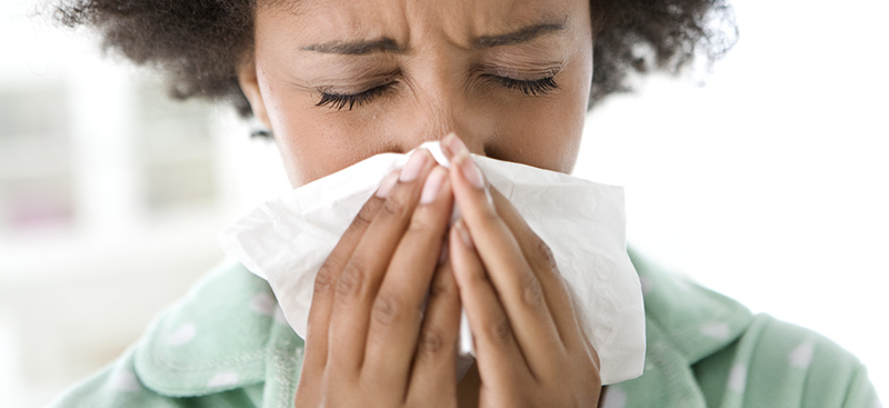 Woman Blowing Her Nose --- Image by © Michael A. Keller/Corbis