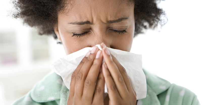 Woman Blowing Her Nose --- Image by © Michael A. Keller/Corbis