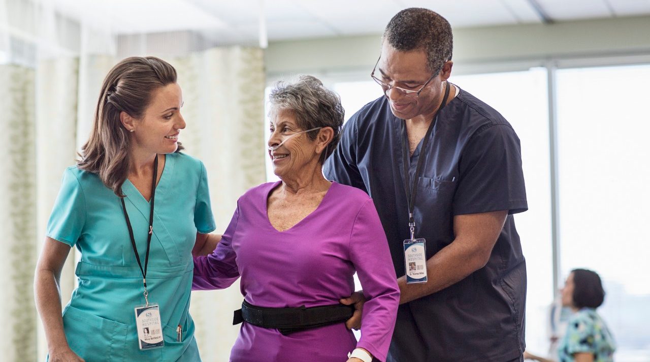 Staff helping patient --- Image by © Isaac Lane Koval/Corbis