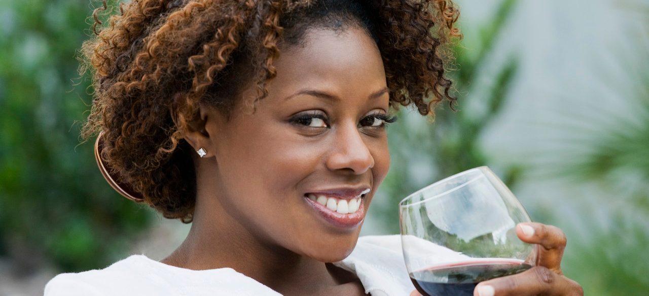 African American woman drinking red wine --- Image by © Inti St. Clair/Blend Images/Corbis