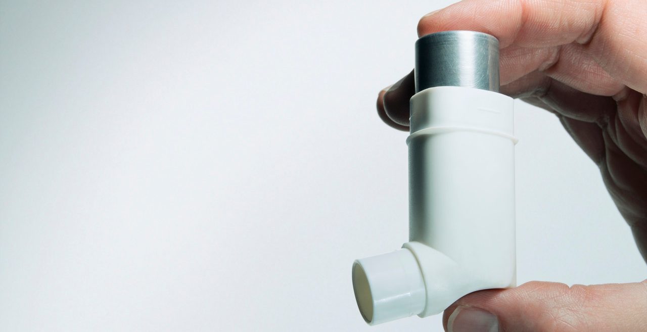 Hand holding asthma inhaler --- Image by © Bernd Vogel/Corbis