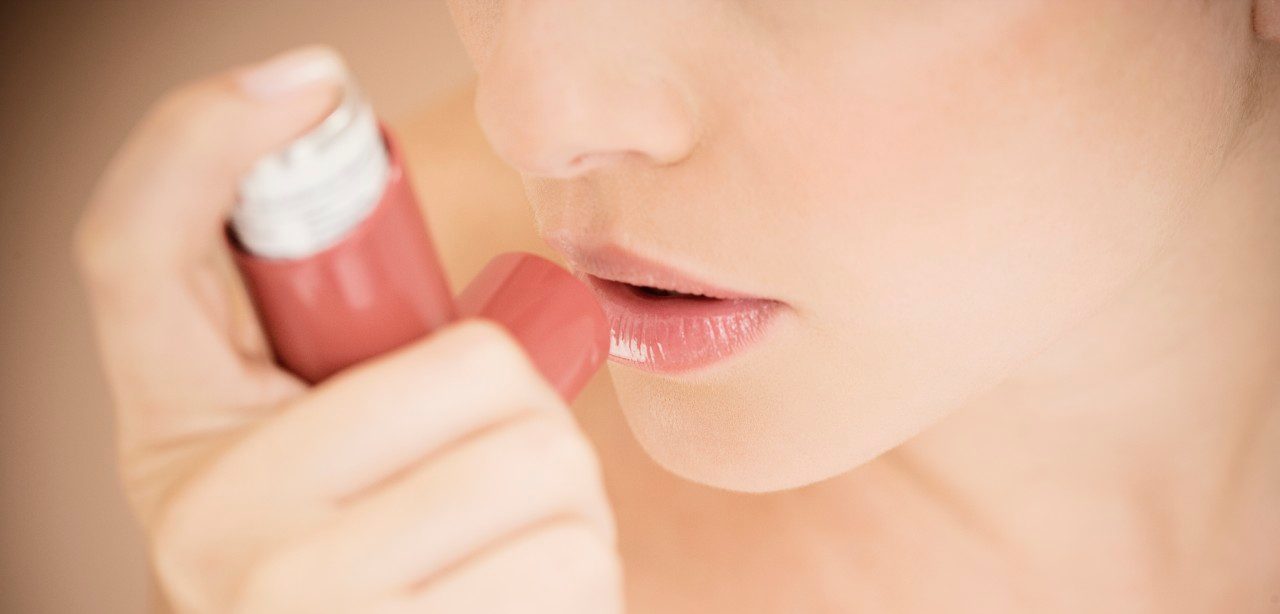 Female asthma sufferer using an inhaler --- Image by © I Love Images/Corbis