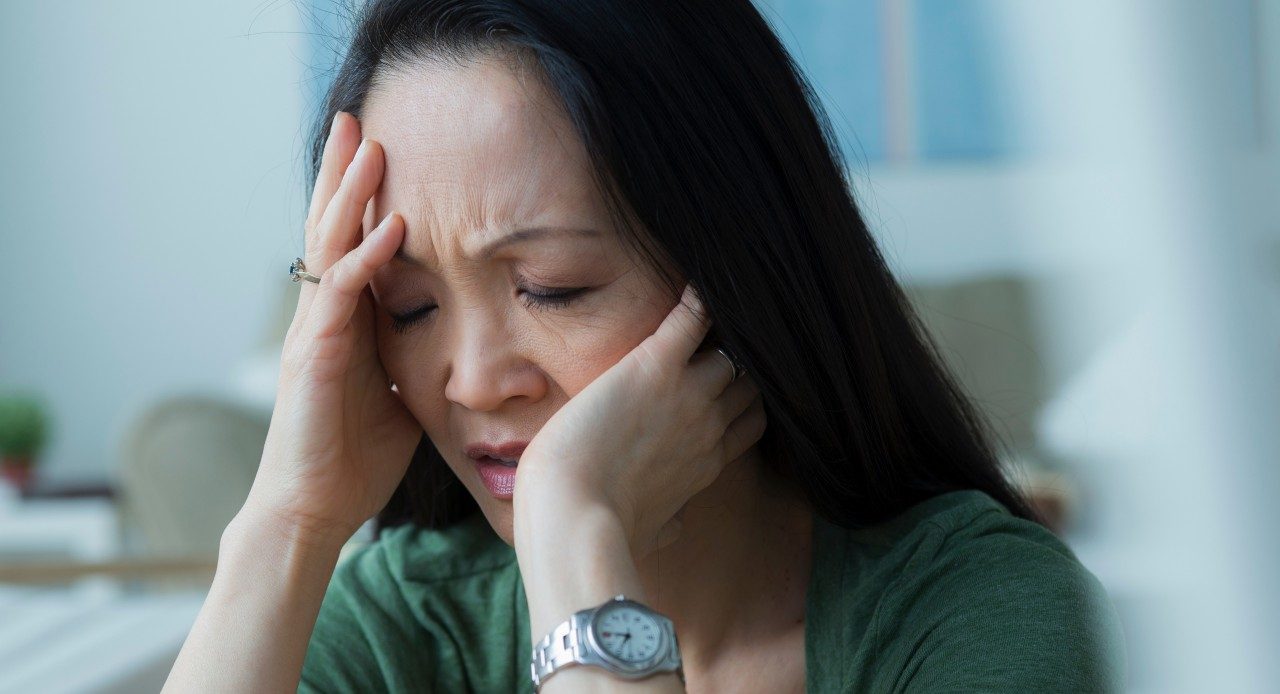 Mature woman with head in hands --- Image by © Rob Lewine/Corbis