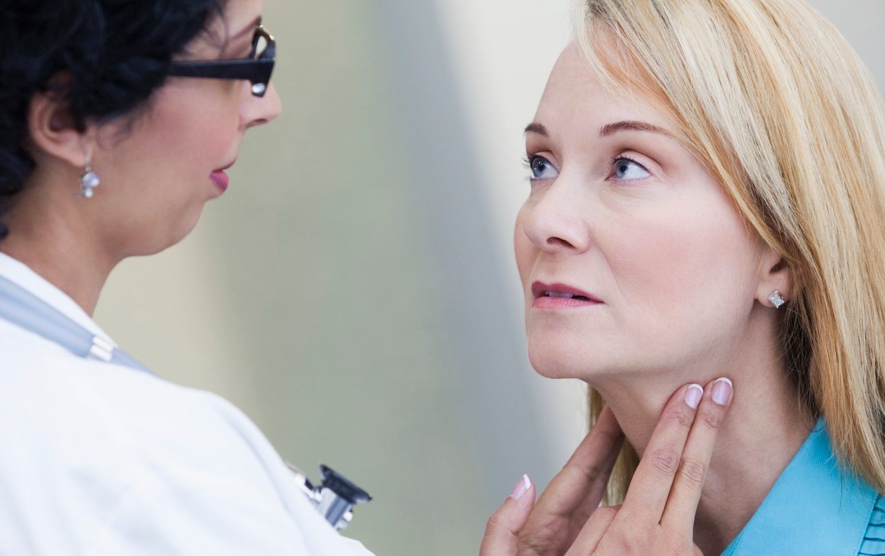 Doctor examining patient's lymph nodes --- Image by © Kate Kunz/Corbis