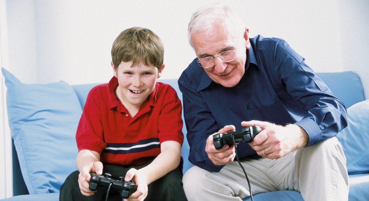 Grandfather and Grandson Playing Video Game --- Image by © Image Source/Corbis