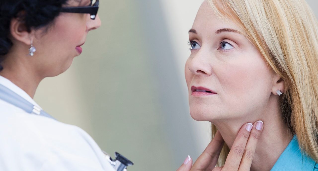 Doctor examining patient's lymph nodes --- Image by © Kate Kunz/Corbis