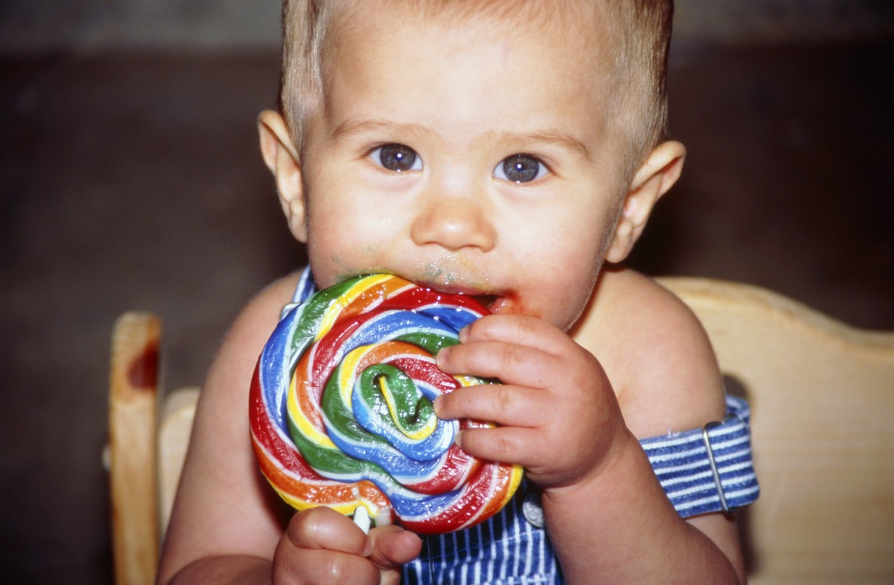 Baby Eating a Big Lollipop --- Image by © KG-Photography/Corbis