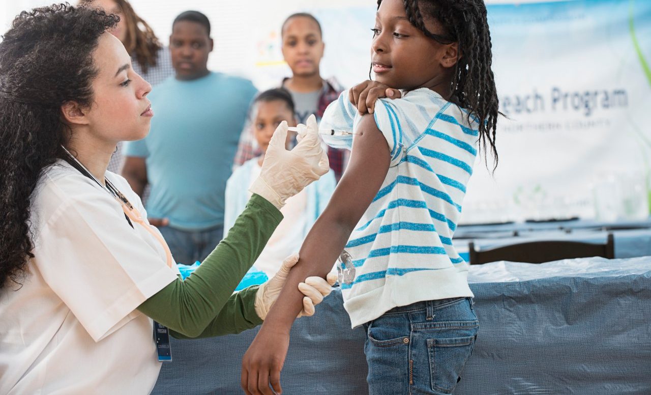 Girl (8-9) being vaccinated --- Image by © Jose Luis Pelaez/Corbis