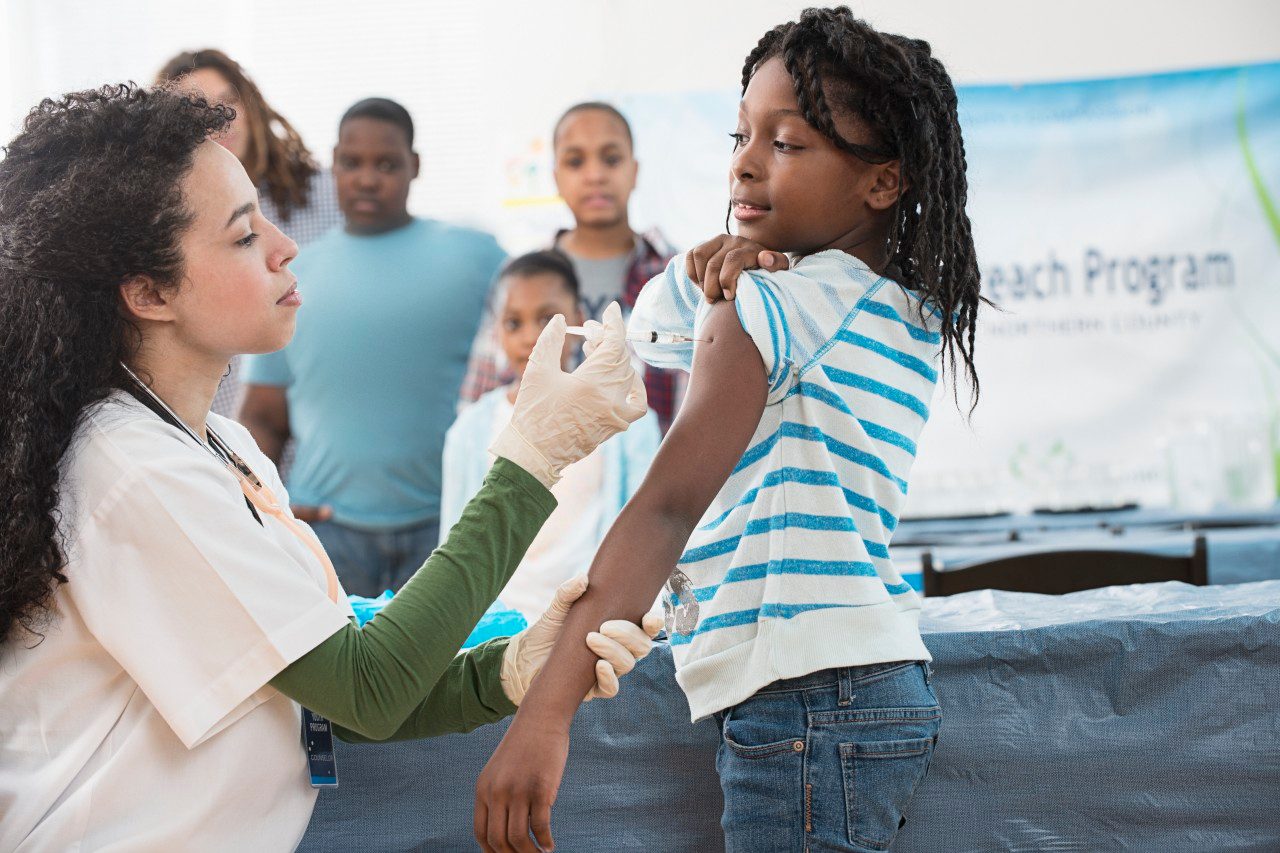 Girl (8-9) being vaccinated --- Image by © Jose Luis Pelaez/Corbis