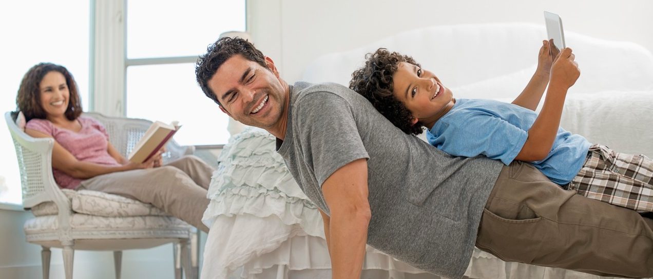 Father playing with his son while mother is watching them --- Image by © Hiya Images/Corbis