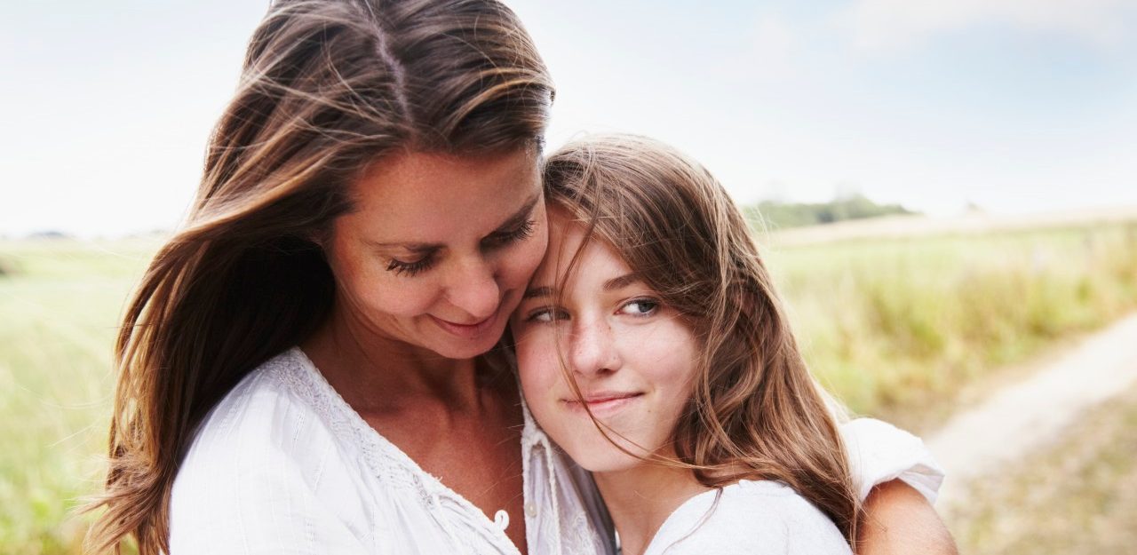 Portrait of mother embracing her daughter (13-15) outdoors --- Image by © Silke Woweries/Corbis