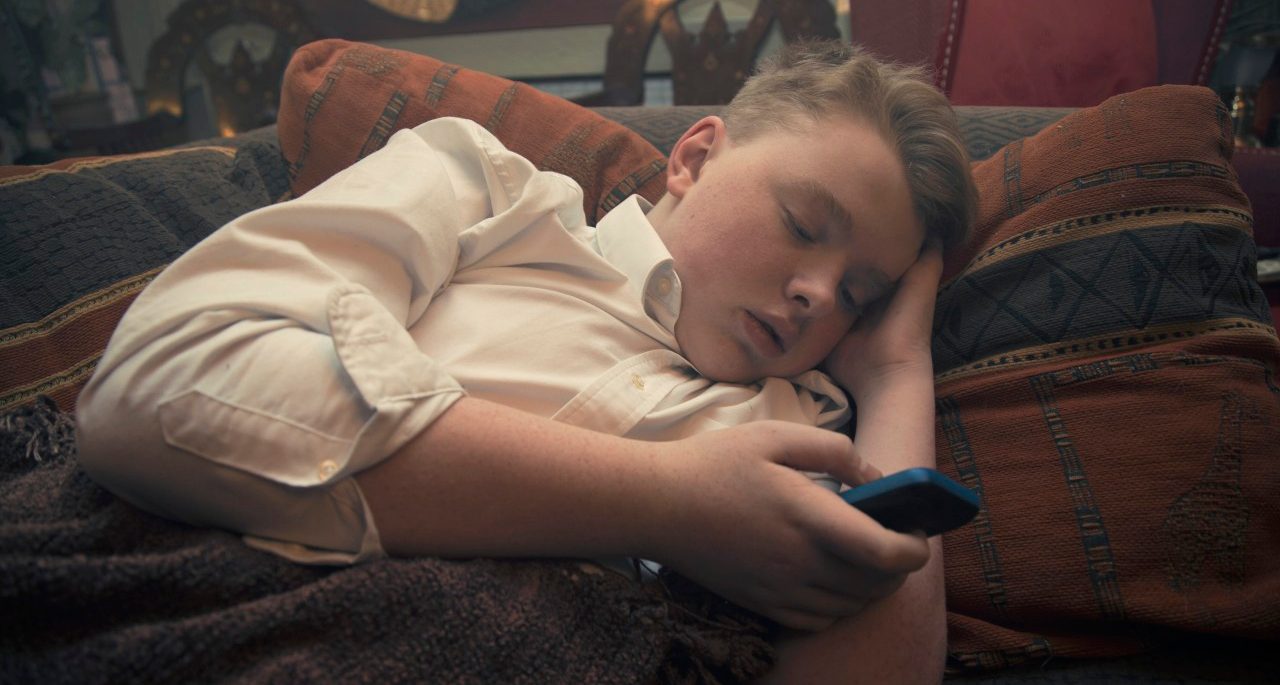 20 Oct 2014 --- Teenager laying on the soafe and using smartphone --- Image by © 3photo/Corbis