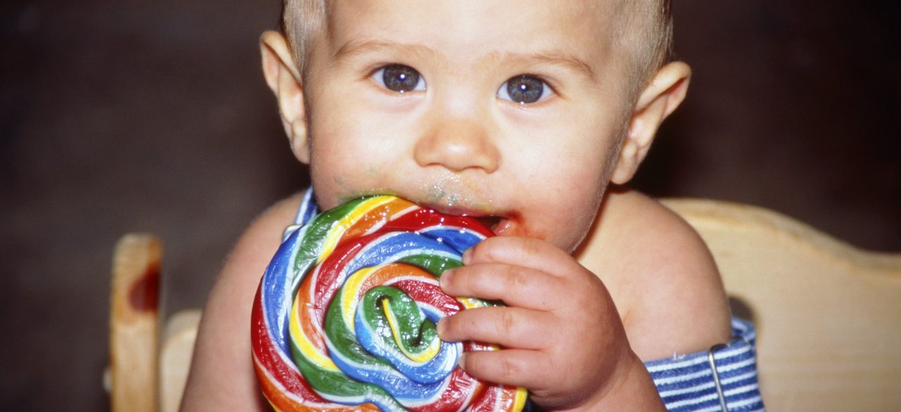 Baby Eating a Big Lollipop --- Image by © KG-Photography/Corbis