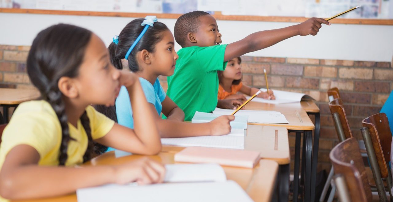 11 May 2014 --- Cute pupil raising hand in classroom --- Image by © Wavebreak Media LTD/Wavebreak Media Ltd./Corbis