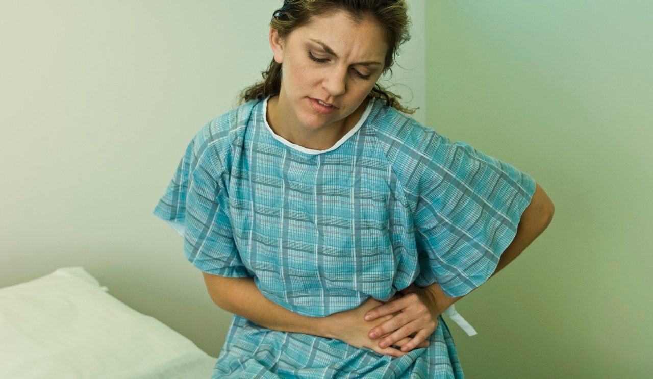 Female patient experiencing severe abdominal pain --- Image by © Michele Constantini/PhotoAlto/Corbis