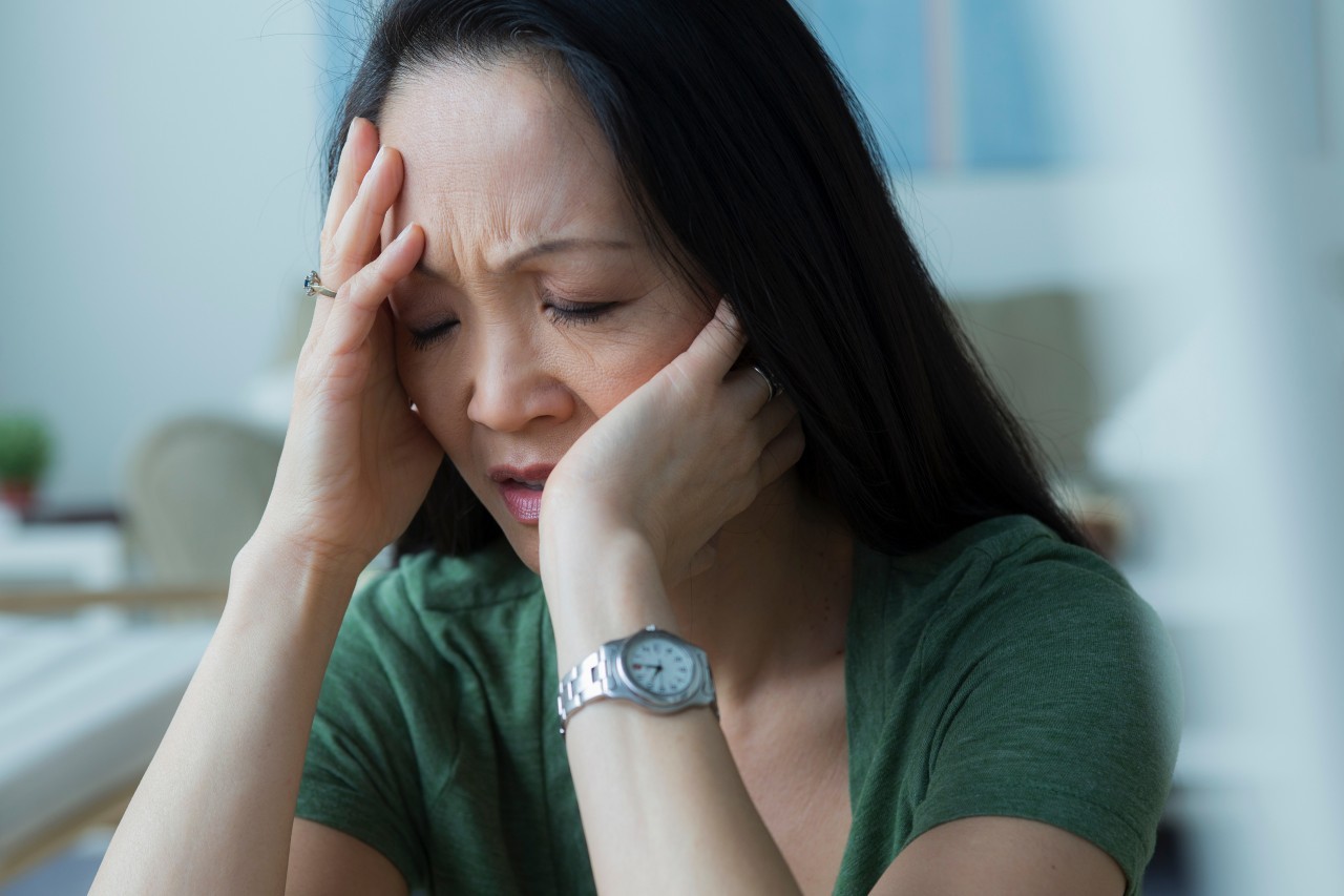 Mature woman with head in hands --- Image by © Rob Lewine/Corbis