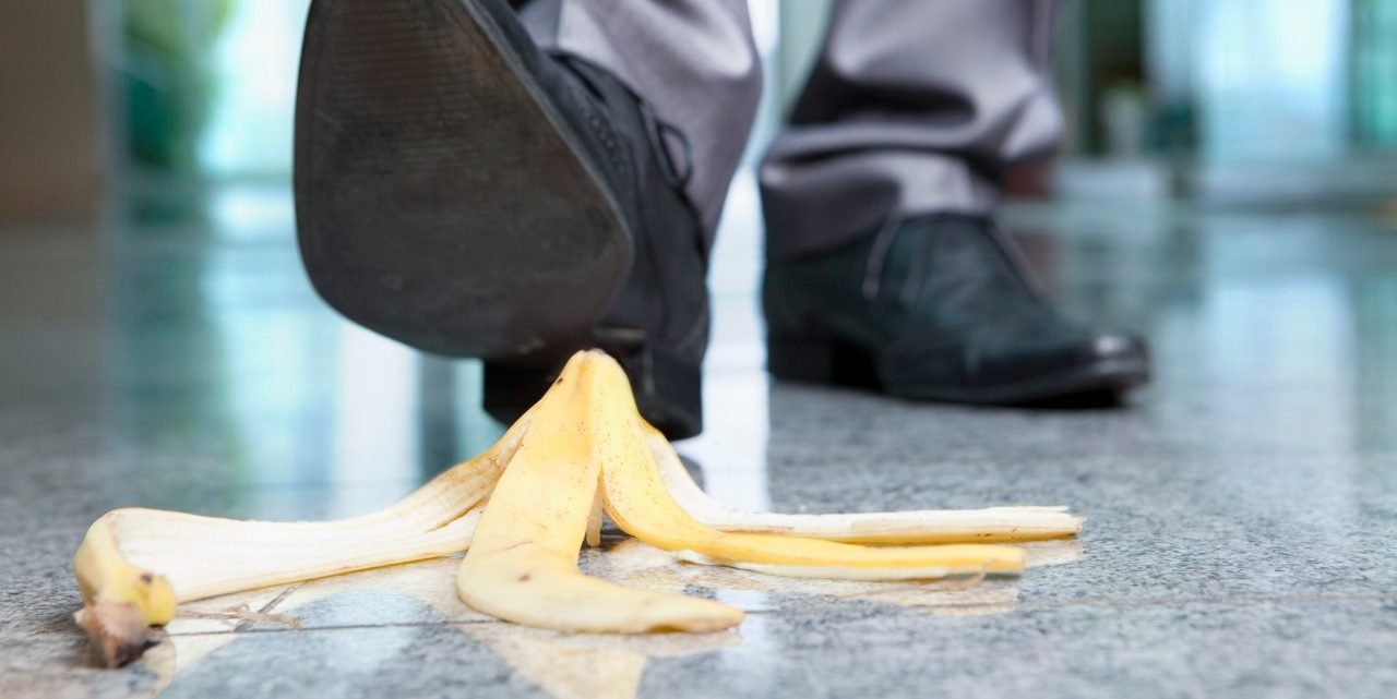 Businessman stepping on banana peel --- Image by © Juice Images/Corbis