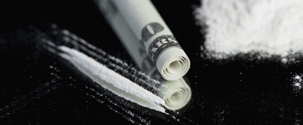 Pile of white substance beside rolled up note and line --- Image by © Wavebreak Media Ltd./Corbis