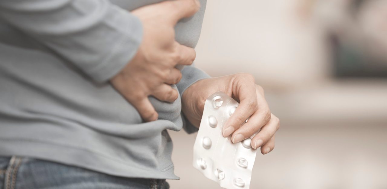 01 Feb 2015 --- Mid-section photo of the woman suffering from stomach ache with pain reliever --- Image by © Arman Zhenikeyev/Corbis