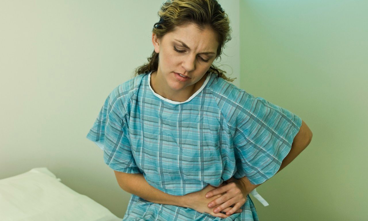 Female patient experiencing severe abdominal pain --- Image by © Michele Constantini/PhotoAlto/Corbis