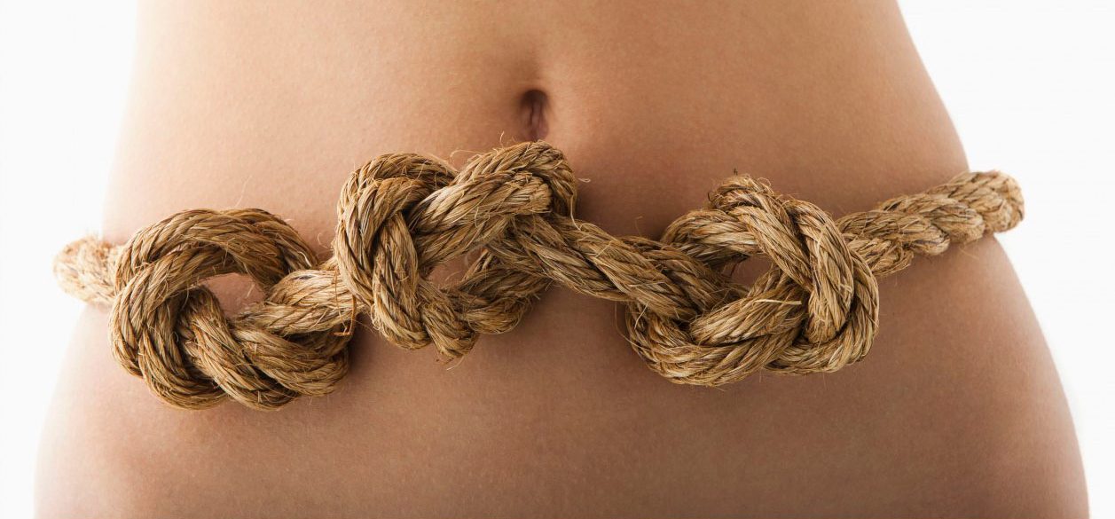 Young woman with knots in stomach --- Image by Â© Mike Kemp/Tetra Images/Corbis