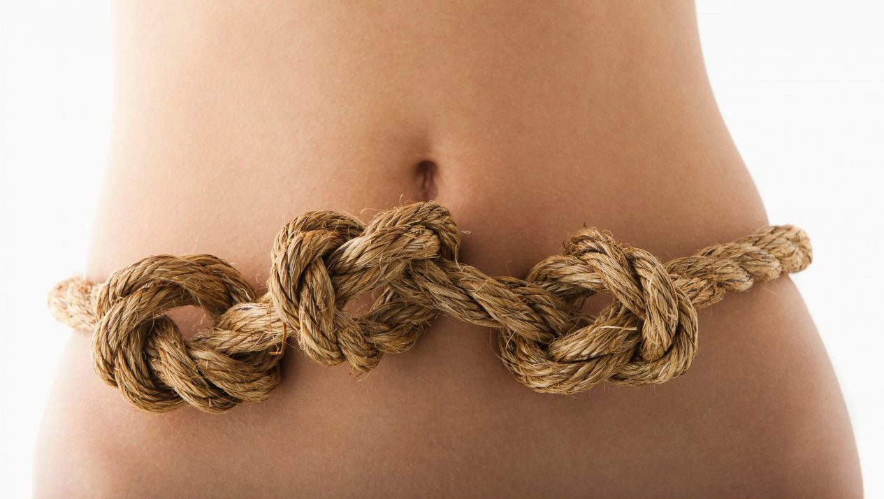 Young woman with knots in stomach --- Image by Â© Mike Kemp/Tetra Images/Corbis