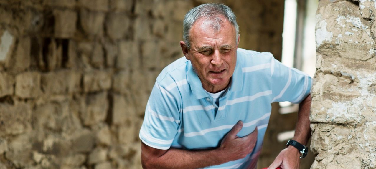 Construction worker clutching his chest --- Image by © Colin Hawkins/cultura/Corbis