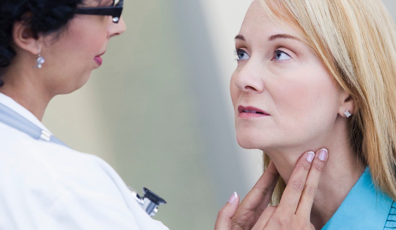 Doctor examining patient's lymph nodes --- Image by © Kate Kunz/Corbis