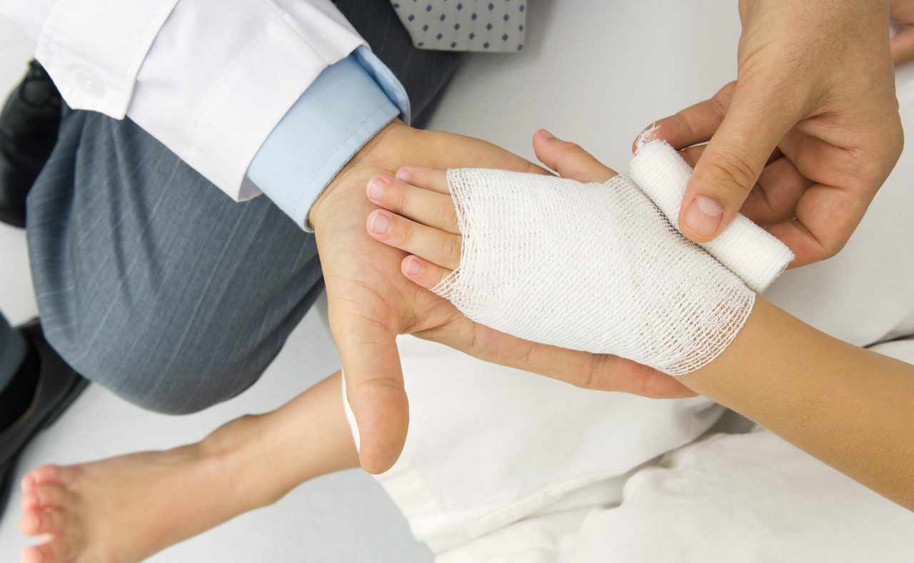 Doctor Wrapping a Patient's Hand in Gauze,high Angle View --- Image by © Odilon Dimier/PhotoAlto/Corbis