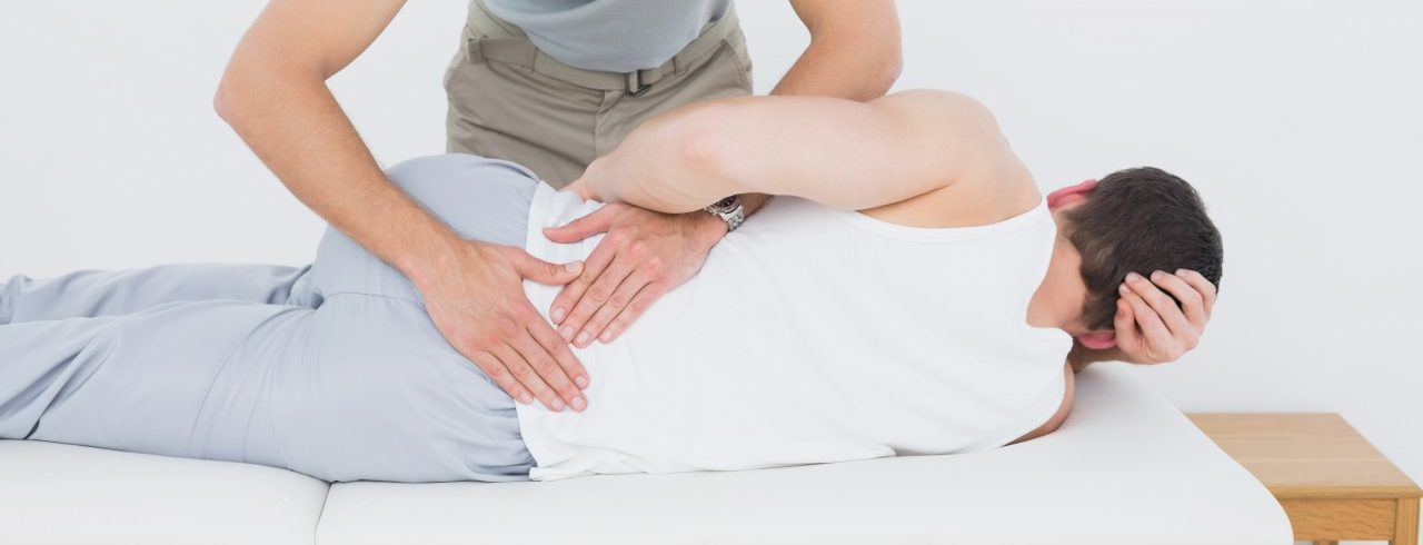 02 Oct 2013 --- Male physiotherapist examining mans back --- Image by © LightWave/Corbis