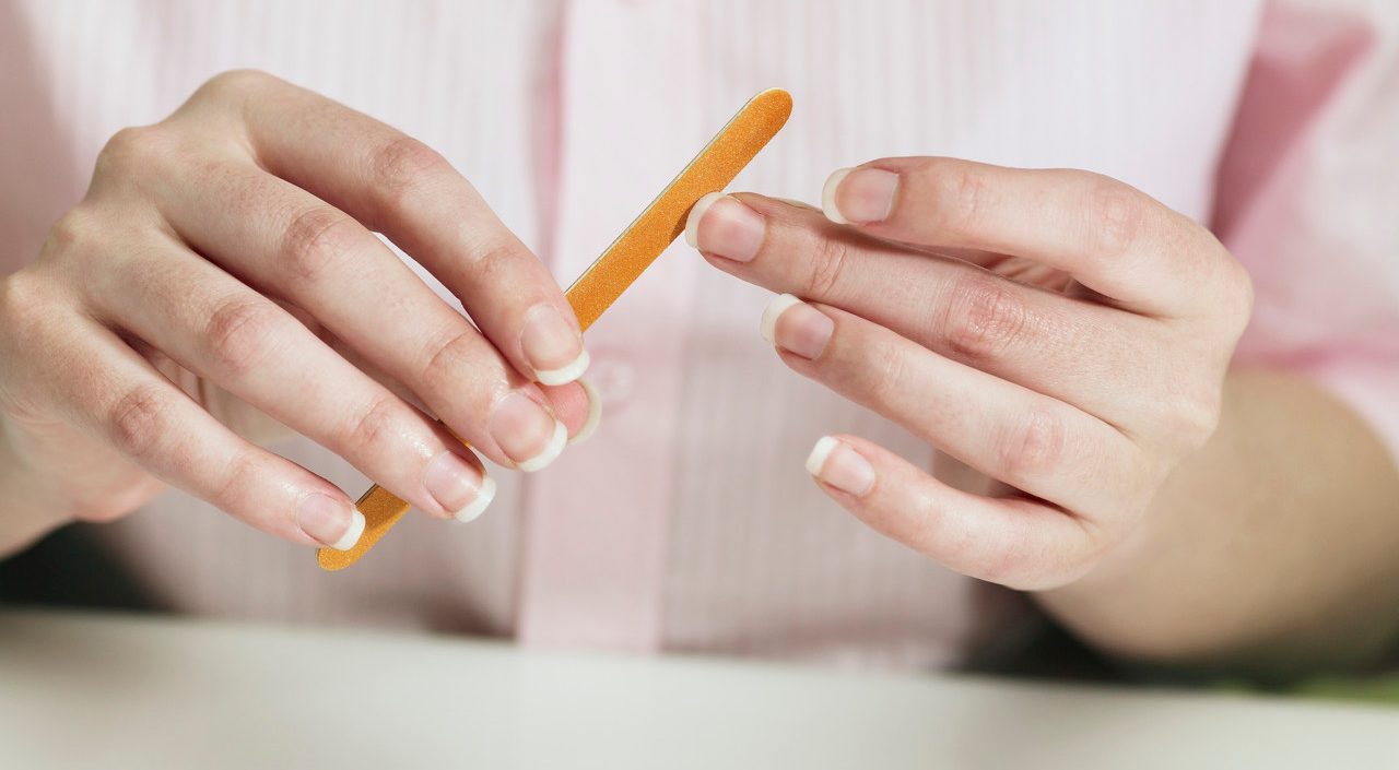 Woman filing her fingernails --- Image by © Mark Weiss/Corbis