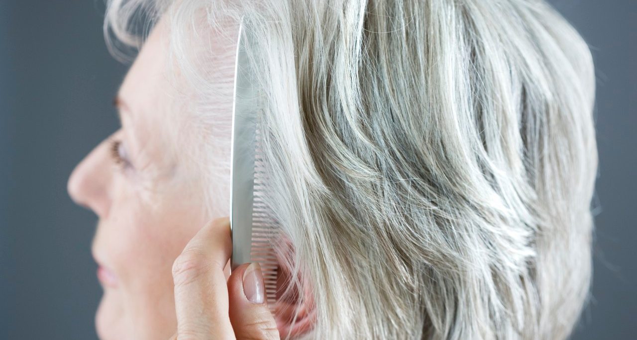 A senior woman combing her hair --- Image by © I Love Images/Corbis