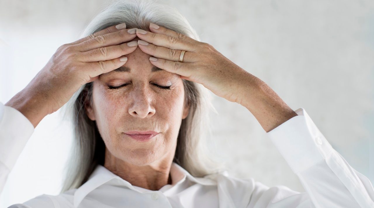 19 Feb 2015 --- Portrait of mature woman meditating with hands on forehead --- Image by © Gary John Norman/Corbis