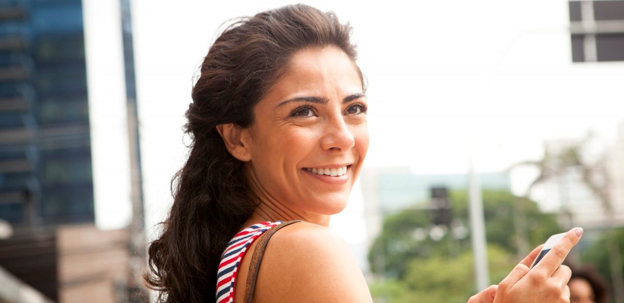 São Paulo, Brazil --- Woman smiles off camera in business district, Sao Paulo, Brazil --- Image by © JAG Images/Corbis