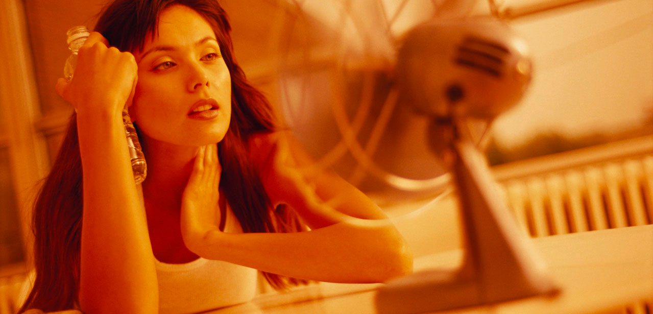 Woman Trying to Cool Off with Fan --- Image by Â© Jim Craigmyle/CORBIS