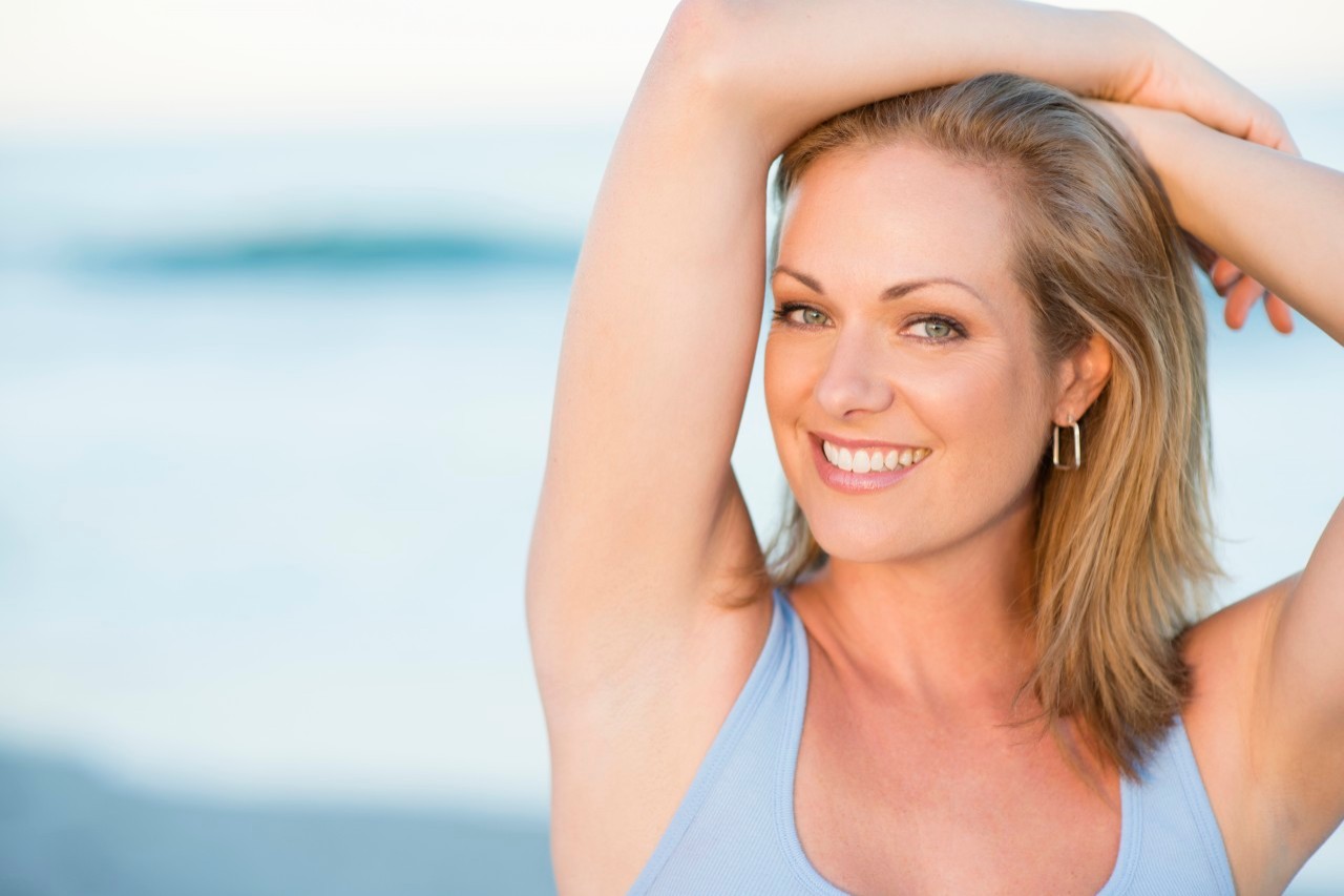 16 Oct 2014, Delray Beach, Florida, USA --- Caucasian woman smiling on beach --- Image by © Rick Gomez/Blend Images/Corbis