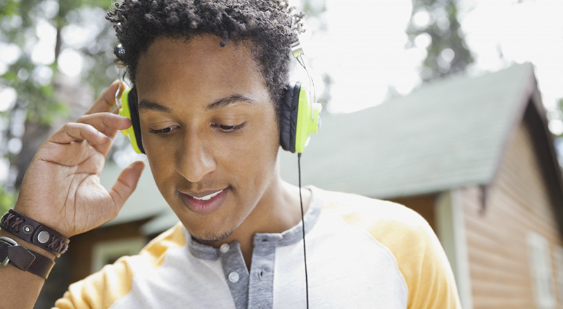 04 Jul 2013, Banff, Banff National Park, Alberta, Canada --- Close-up of man standing outdoors with headphones on --- Image by © Hero Images/Corbis