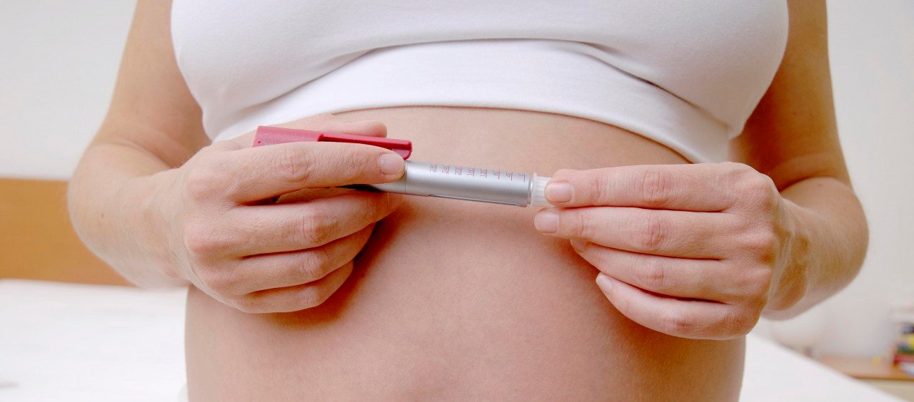 Germany --- Pregnant woman holding insulin pen  --- Image by © Doc-Stock/Corbis