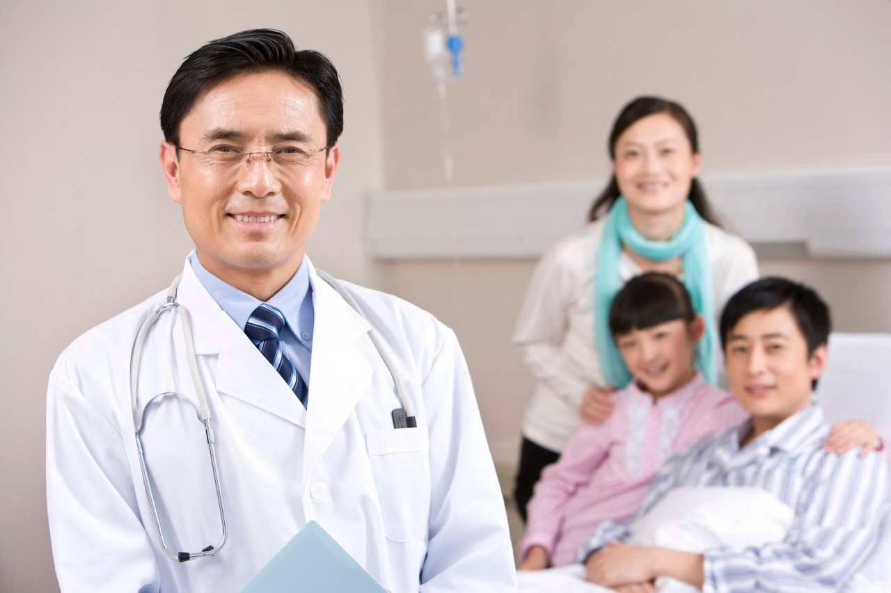 Kunming, Yunnan Province, China --- Portrait of a doctor with his patient and his patient's family --- Image by © Lane Oatey/Blue Jean Images/Corbis