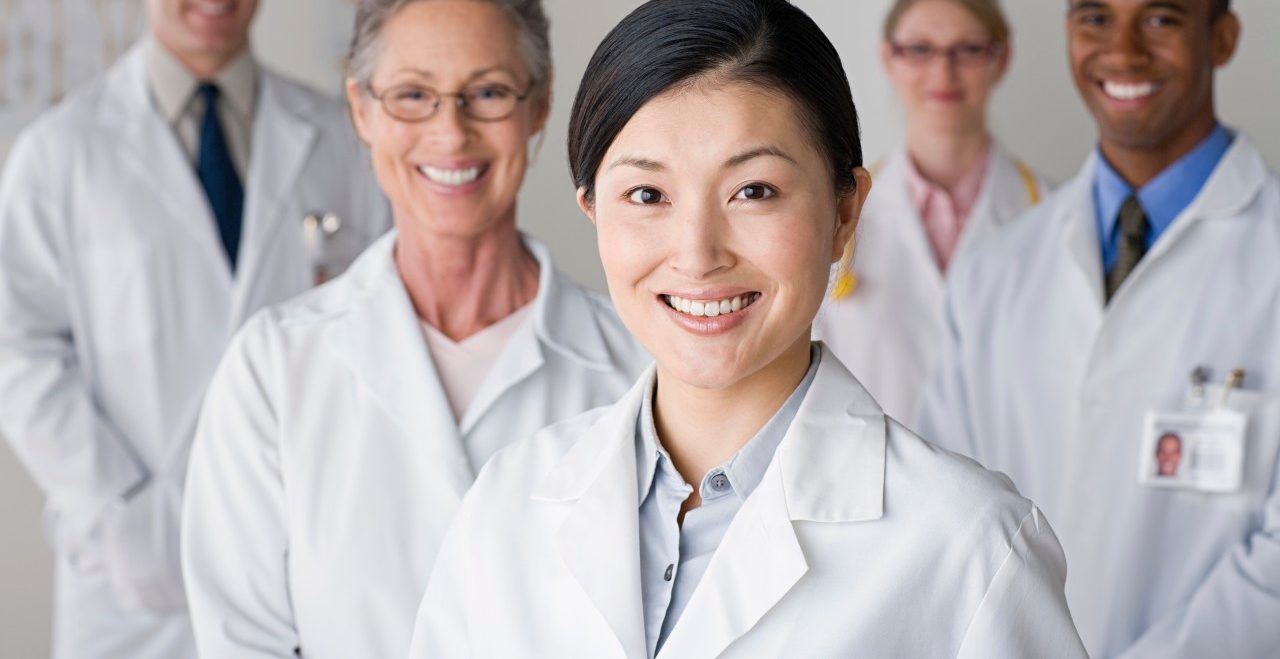 USA, California, Los Angeles, Group portrait of smiling doctors --- Image by © Rob Lewine/Tetra Images/Corbis