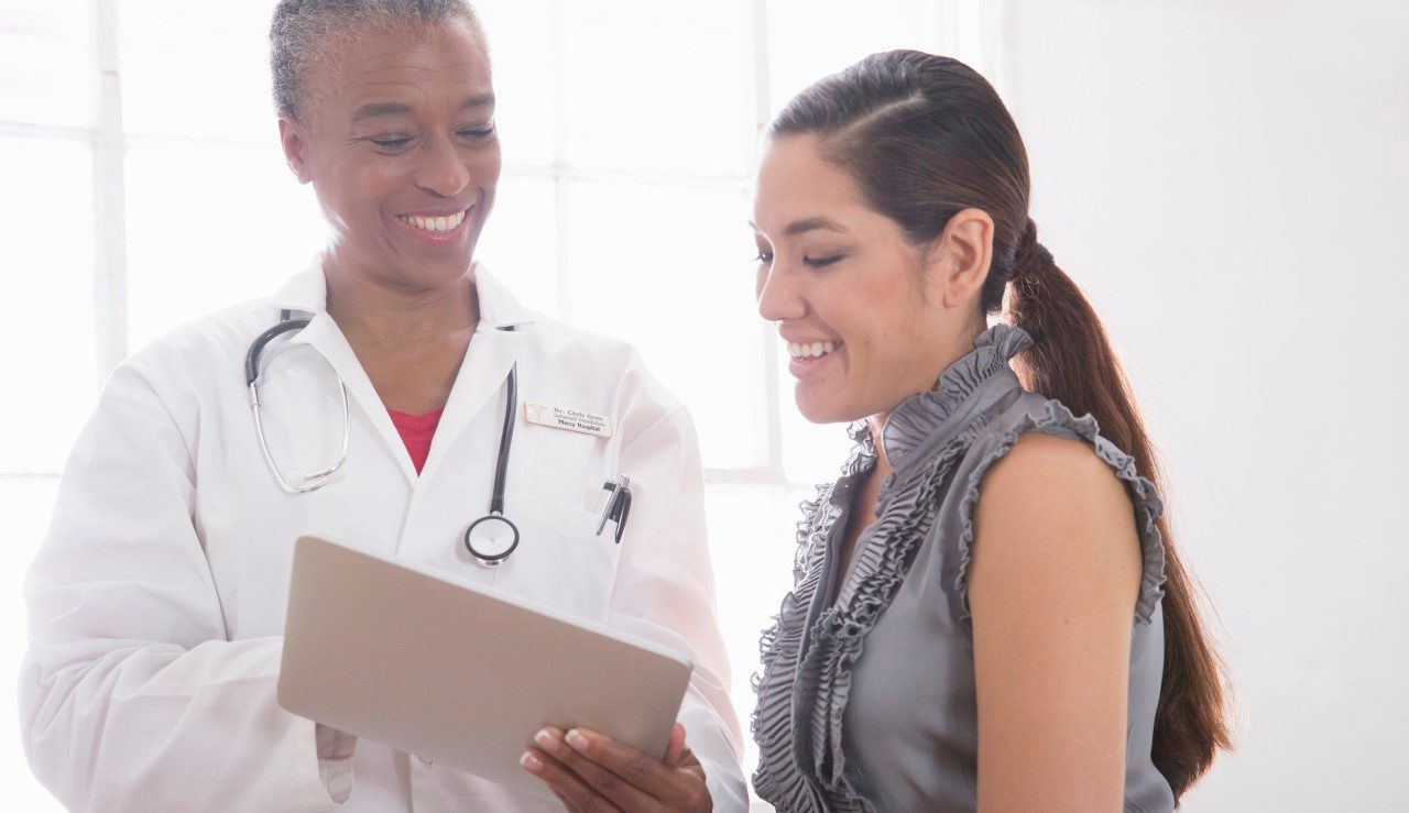 31 Aug 2014 --- Female doctor showing patient digital tablet --- Image by © David Jakle/Corbis