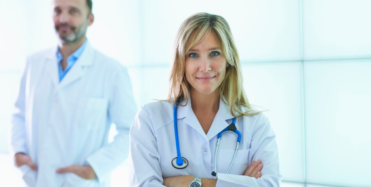 31 Oct 2014 --- Doctors posing against backlit wall panel --- Image by © Corbis