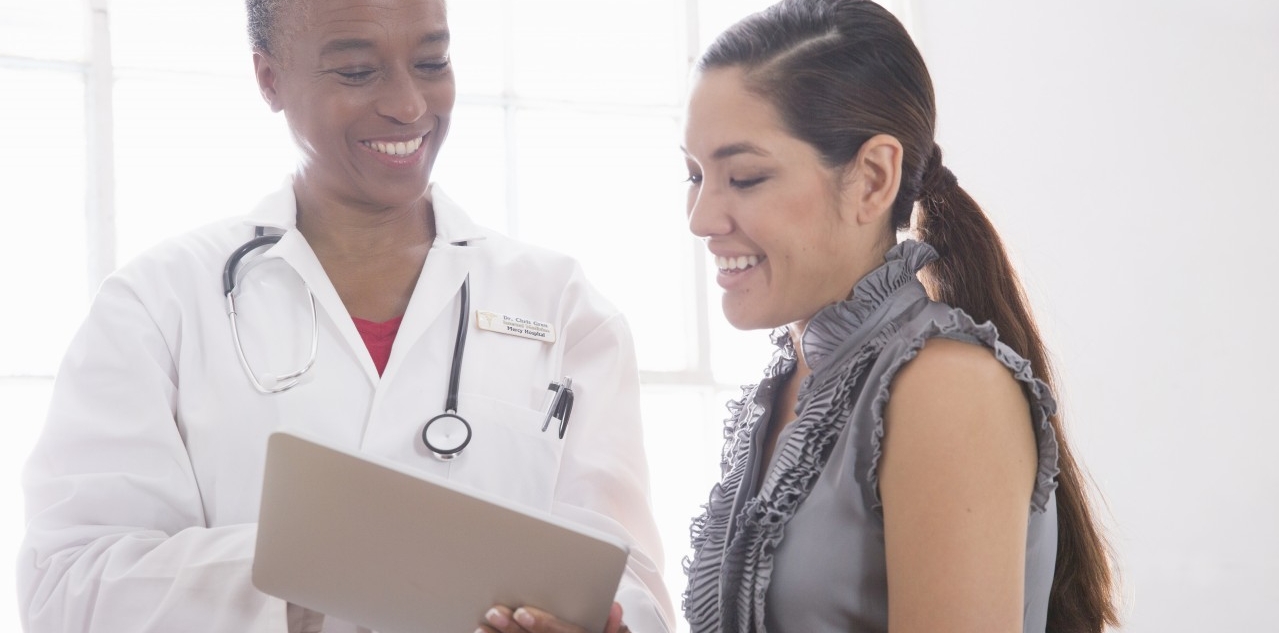 31 Aug 2014 --- Female doctor showing patient digital tablet --- Image by © David Jakle/Corbis