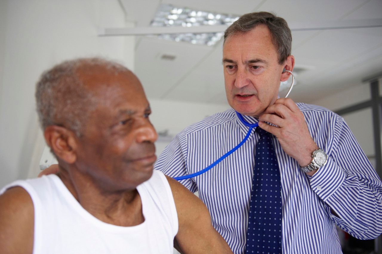 Doctor with stethoscope with elderly man --- Image by © Janie Airey/cultura/Corbis