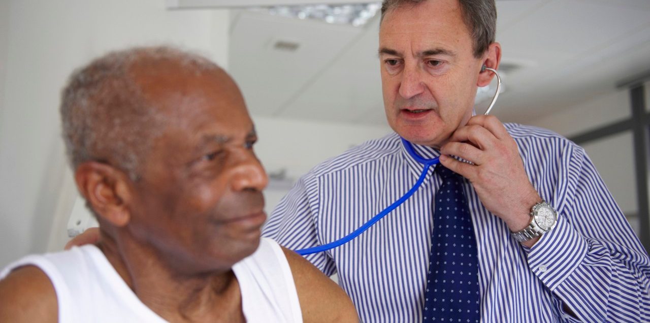 Doctor with stethoscope with elderly man --- Image by © Janie Airey/cultura/Corbis