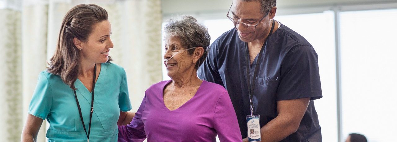 Staff helping patient --- Image by © Isaac Lane Koval/Corbis